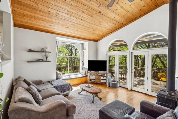 a living room with furniture floor to ceiling window and a flat screen tv