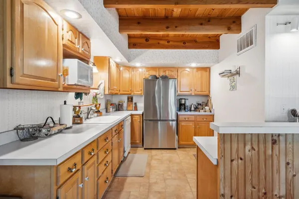 a kitchen with stainless steel appliances granite countertop a refrigerator a sink and dishwasher