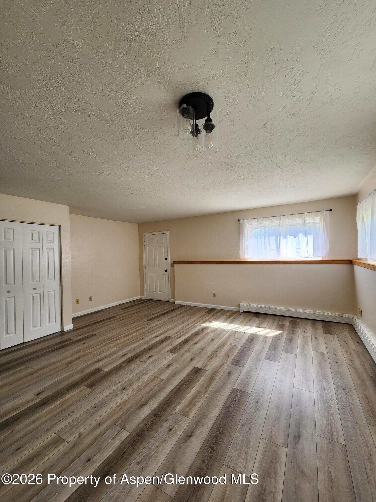 883 Taugenbaugh Boulevard Rifle, CO 81650 - Photo 7 of 18 wooden floor in an empty room with a window
