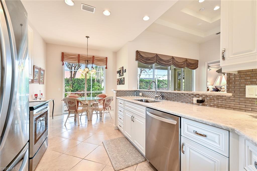3359 Sandpiper Way Naples, FL 34109 - Photo 13 of 41 a kitchen with lots of counter top space and dining table