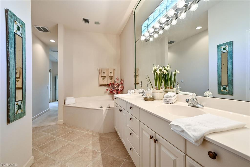 3359 Sandpiper Way Naples, FL 34109 - Photo 20 of 41 a spacious bathroom with a double vanity sink mirror and bathtub