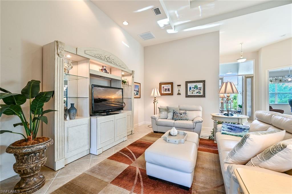 3359 Sandpiper Way Naples, FL 34109 - Photo 6 of 41 a living room with furniture a flat screen tv and a floor to ceiling window