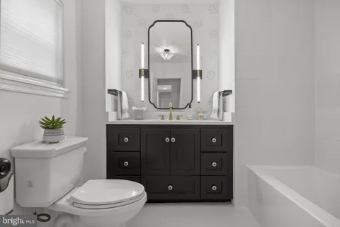 a view of an empty room with wooden floor and windows