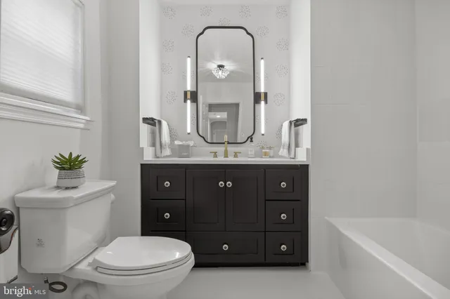 a view of an empty room with wooden floor and windows