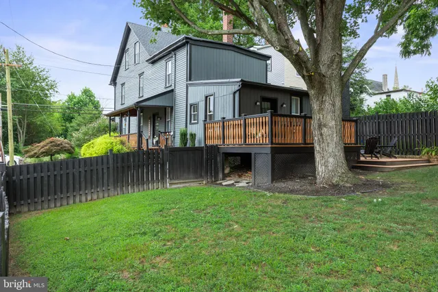 a view of a backyard with a trees and wooden fence