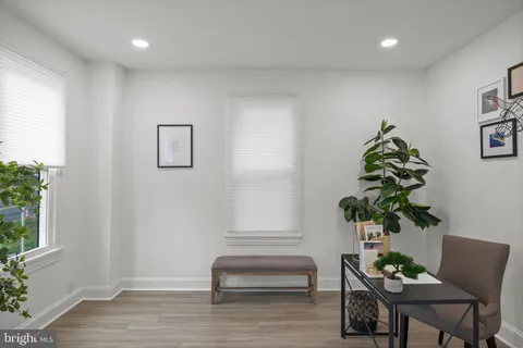 a living room with furniture flowerpot and wooden floor