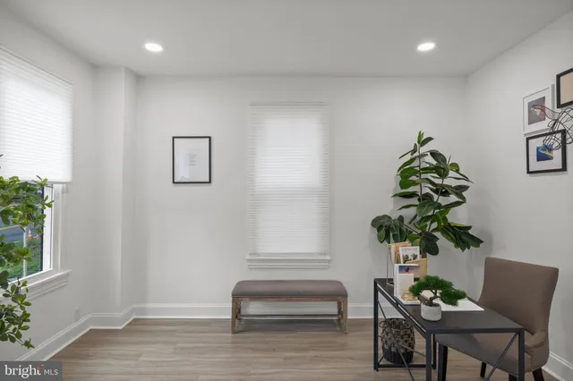 a living room with furniture flowerpot and wooden floor