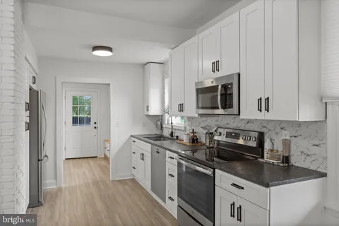 a kitchen with stainless steel appliances granite countertop a sink stove and microwave