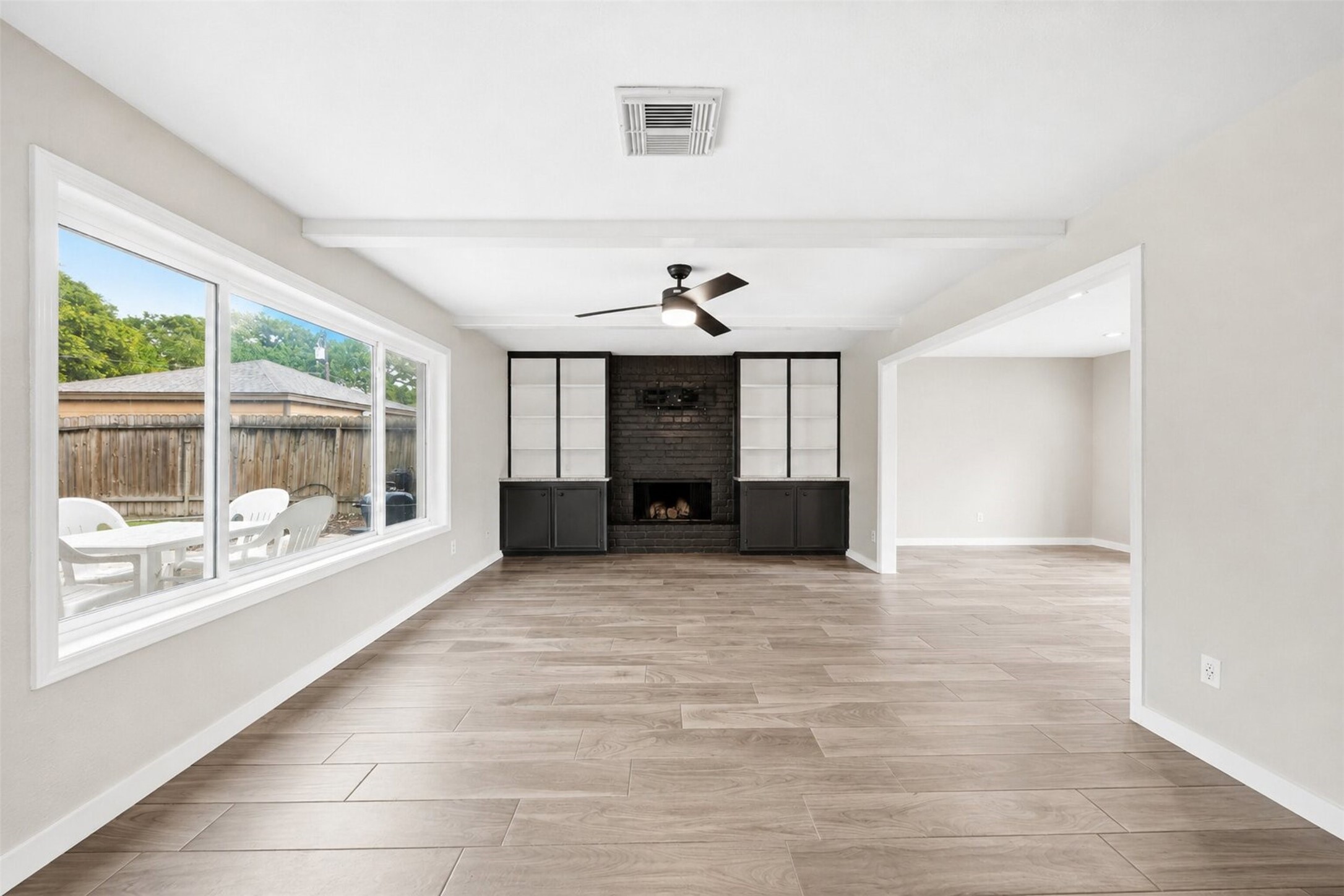 15414 Ripplestream Drive Houston, TX 77068 - Photo 8 of 41 Bright open-concept family room boasting a contemporary wood burning fireplace, custom built-in cabinets, and ceiling beams. The durable tile floor spans across this airy living space, which effortlessly connects to the main kitchen and offers large windows with views of the backyard and pool!