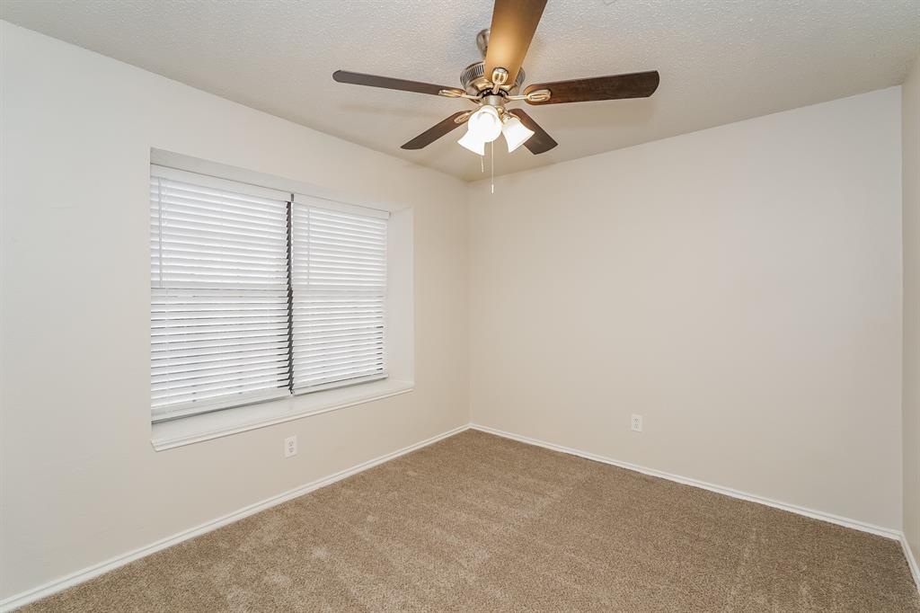 1334 Cedar Ridge Drive Lewisville, TX 75067 - Photo 12 of 16 an empty room with windows and fan