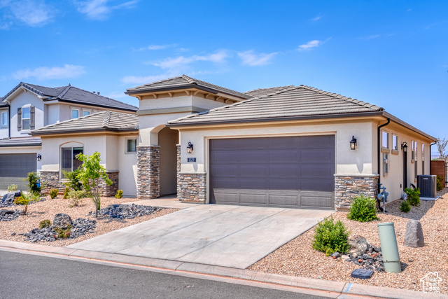 1329 Paseos Street Washington, UT 84780 - Photo 2 of 35 Prairie-style house with stone siding, concrete driveway, stucco siding, an attached garage, and a tile roof