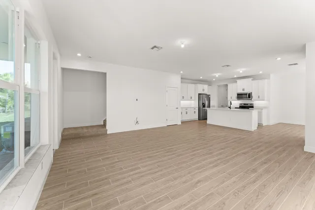 a view of large kitchen with a sink and a refrigerator