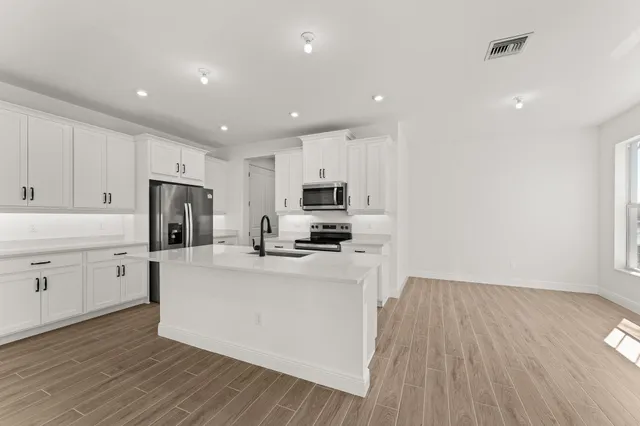 a kitchen with white cabinets and stainless steel appliances