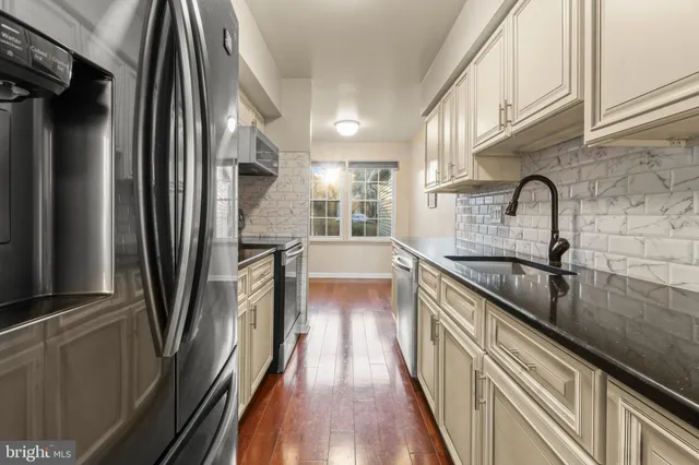 a view of a kitchen with a sink and refrigerator