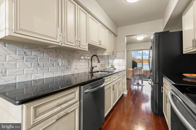 a kitchen with stainless steel appliances granite countertop a sink stove and cabinets