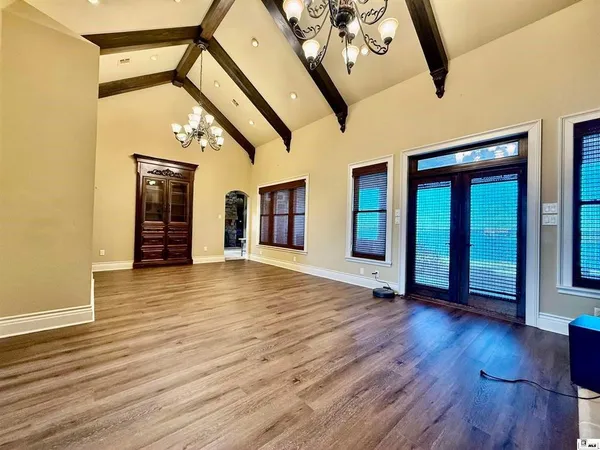 a view of a livingroom with a fireplace a ceiling fan wooden floors and a fireplace