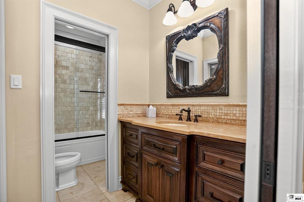 114 Apache Trail Delhi, LA 71232 - Photo 27 of 38 a bathroom with a granite countertop toilet a sink a mirror and a shower