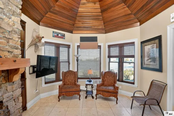 a living room with furniture a flat screen tv and windows