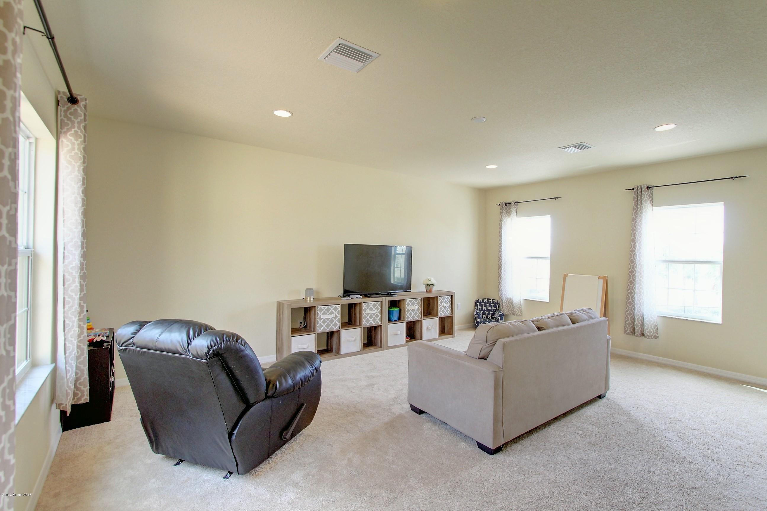3235 Sedge Drive Rockledge, FL 32955 - Photo 17 of 34 a living room with furniture and a flat screen tv