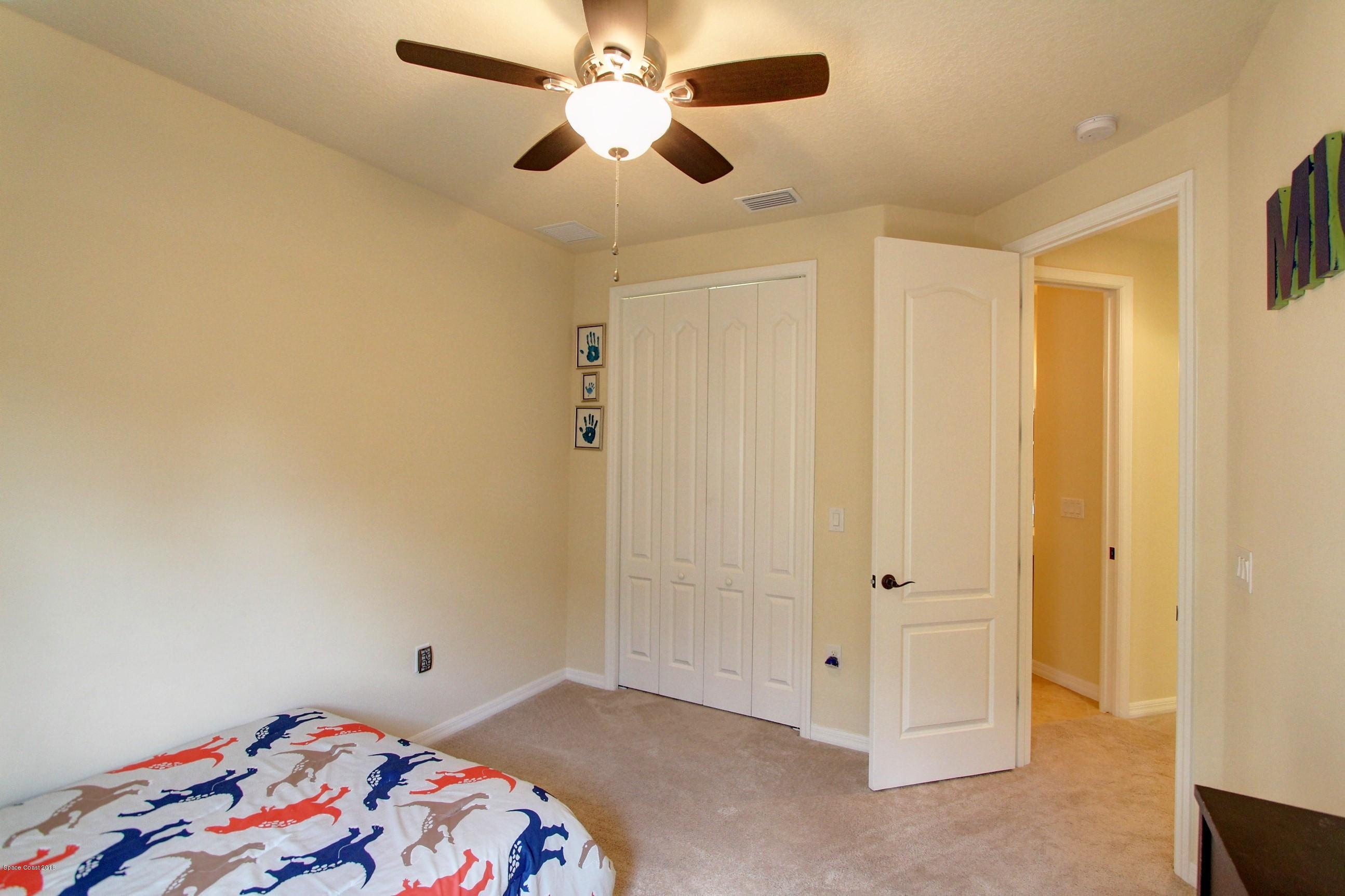 3235 Sedge Drive Rockledge, FL 32955 - Photo 28 of 34 a bedroom with a bed and a chandelier fan