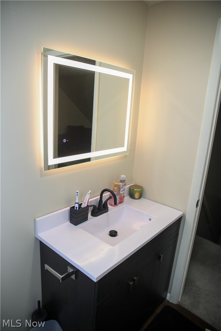 1258 Vane Avenue Akron, OH 44310 - Photo 11 of 12 Modern vanity featuring a dark wood-finish cabinet with double doors and a brushed nickel pull handle
