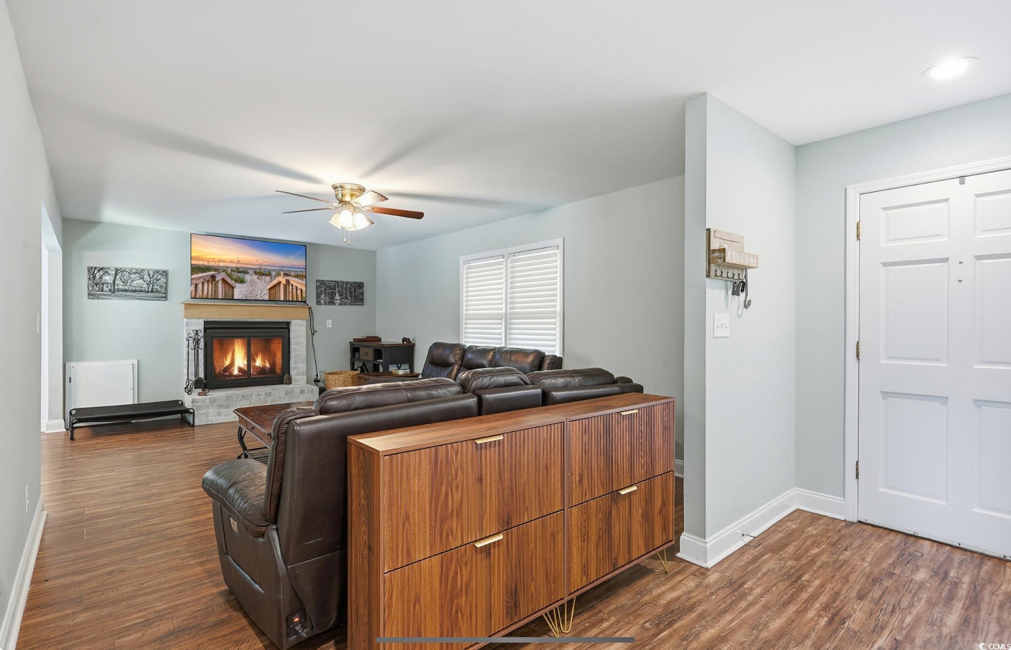 78 Wicklow Way Pawleys Island, SC 29585 - Photo 5 of 37 Living room with dark wood-style floors, a stone fireplace, and ceiling fan