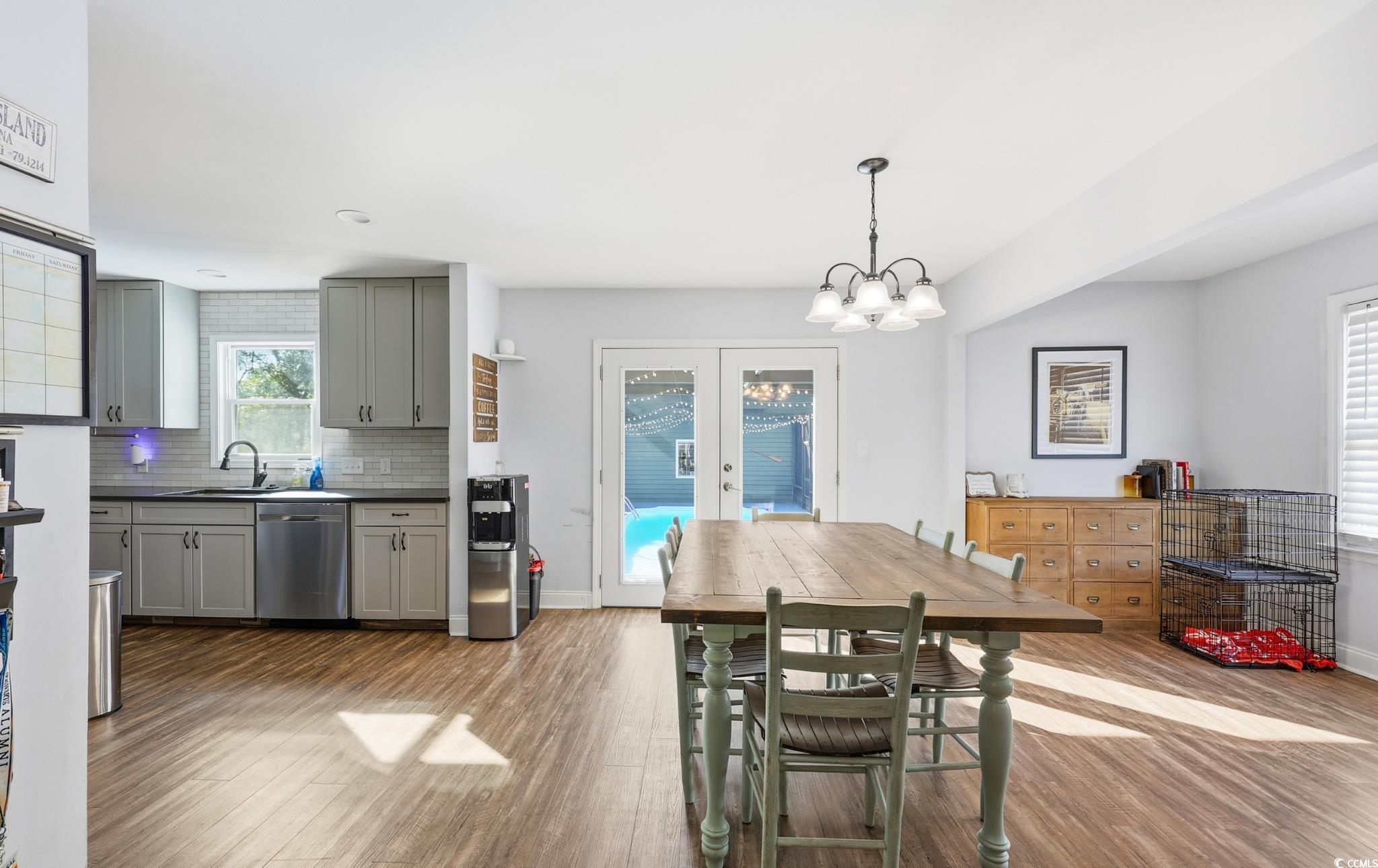 78 Wicklow Way Pawleys Island, SC 29585 - Photo 7 of 37 Dining room featuring light wood-style floors, french doors, and a chandelier