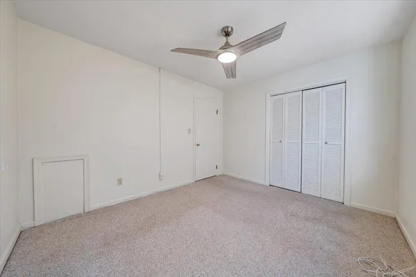 an empty room with a ceiling fan and a window