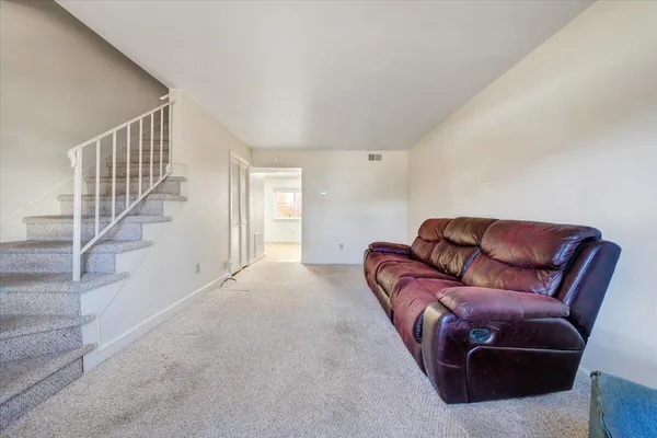 a living room with furniture and stairs