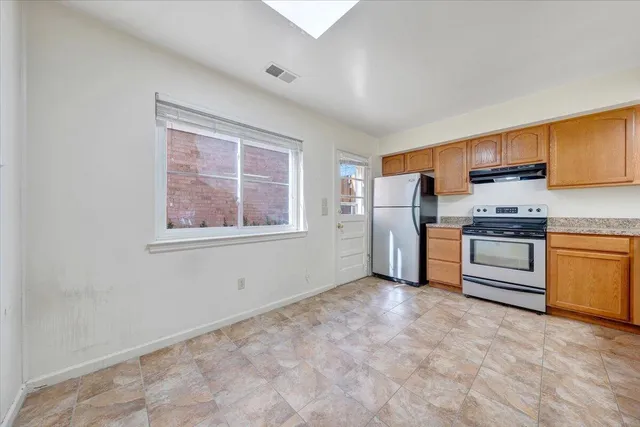 a kitchen with stainless steel appliances a refrigerator and a stove top oven