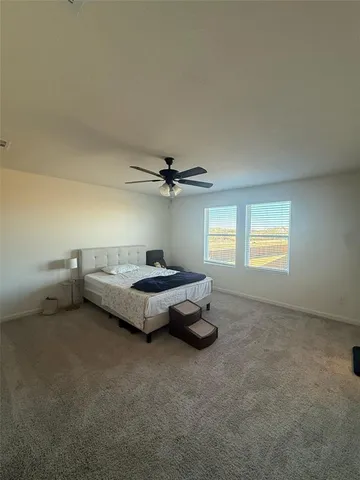 a spacious bedroom with a bed and a chandelier