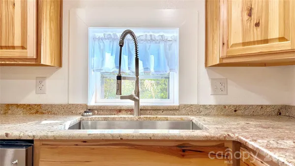 a kitchen with granite countertop a sink and a window