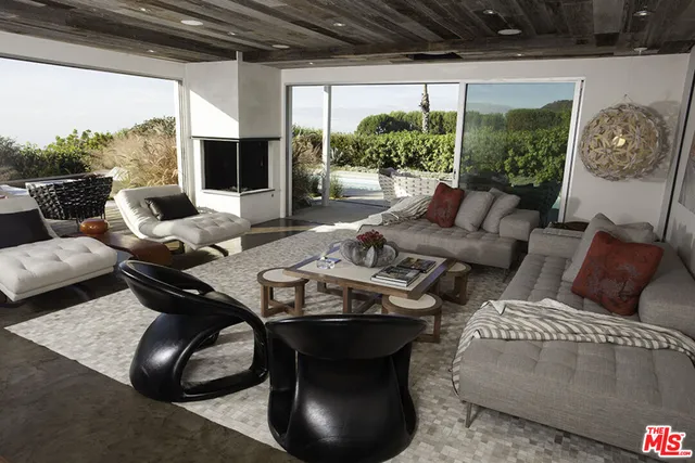 a living room with furniture and a floor to ceiling window