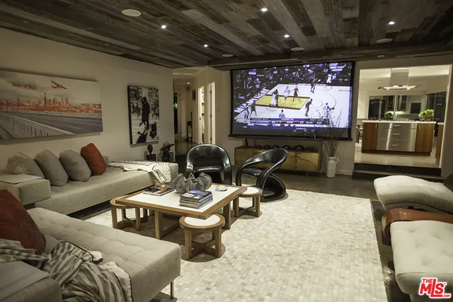 a living room with furniture a rug and a projector