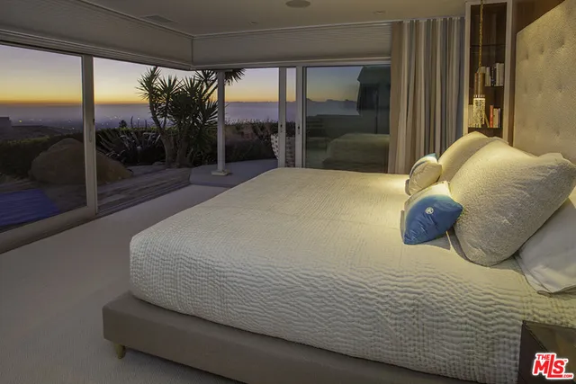 a bedroom with a large bed and a large window