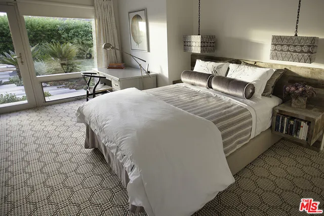 a bedroom with a bed a mirror and lamp