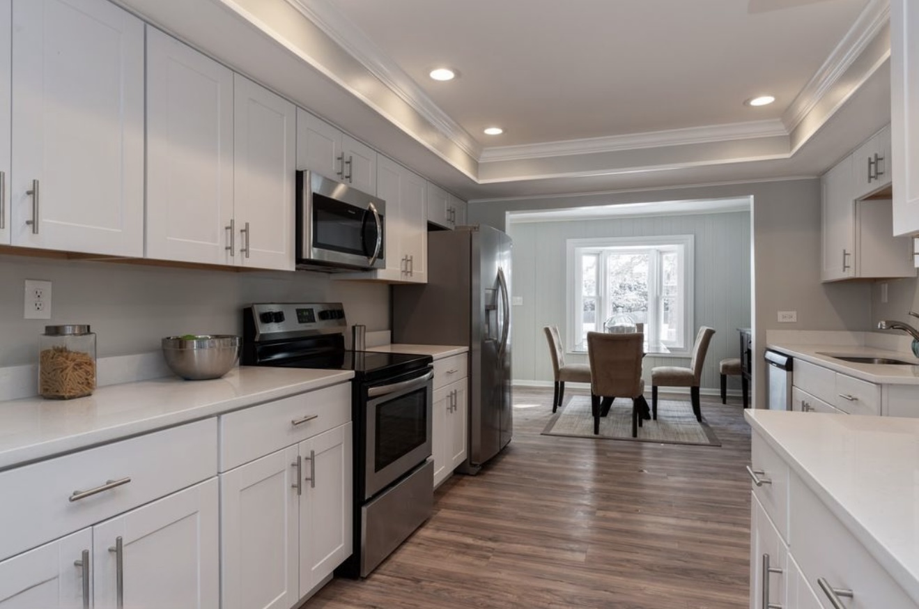 684 Pfingsten Road Northbrook, IL 60062 - Photo 16 of 33 a kitchen with granite countertop cabinets stainless steel appliances a sink and a dining table view