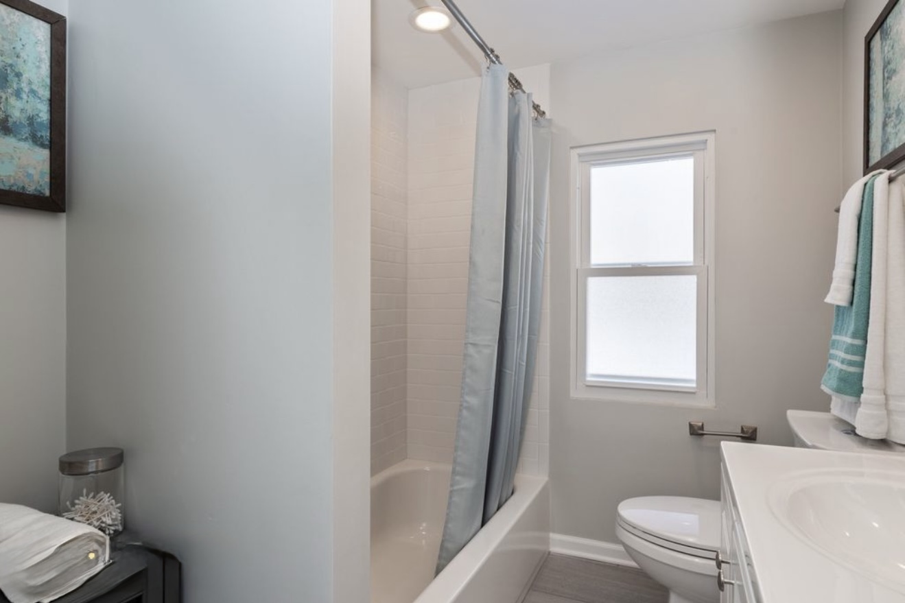 684 Pfingsten Road Northbrook, IL 60062 - Photo 27 of 33 a bathroom with a toilet a sink a vanity and a window