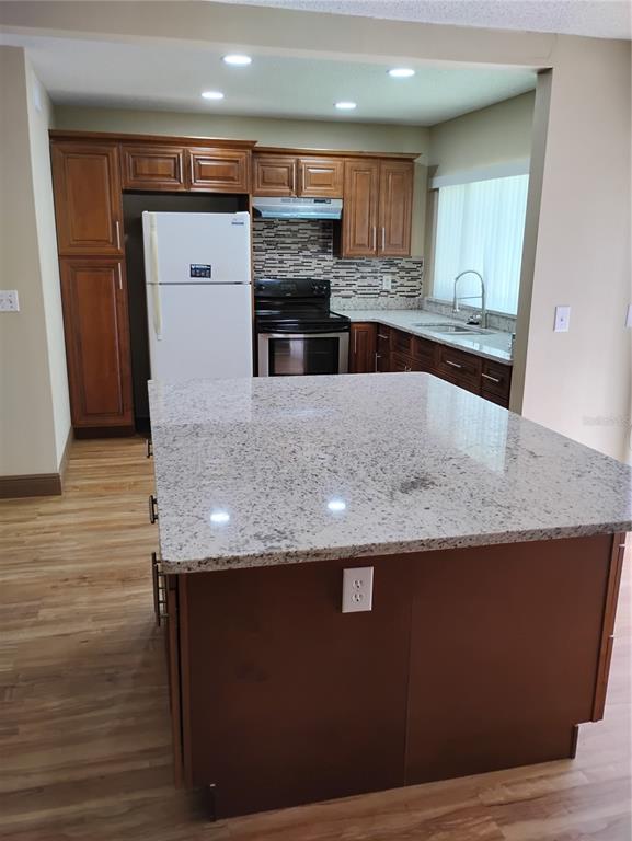 11721 Raintree Drive Tampa, FL 33617 - Photo 2 of 12 a kitchen with granite countertop a stove and a refrigerator