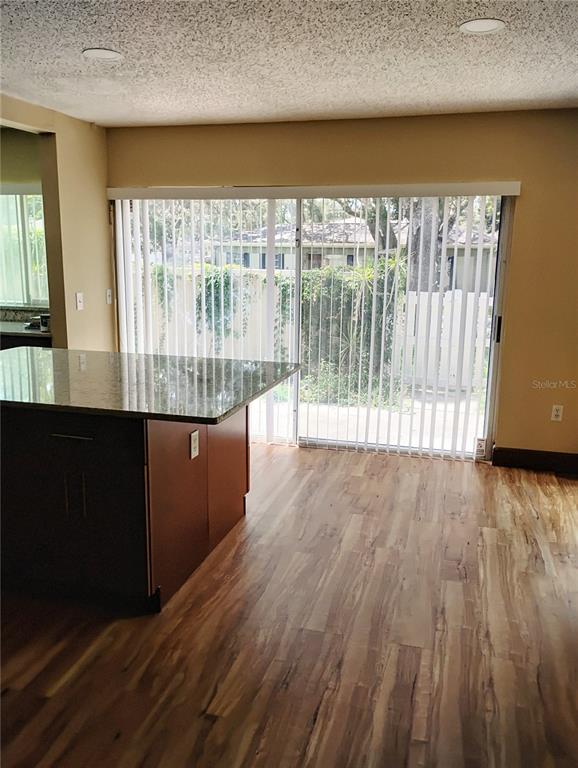 11721 Raintree Drive Tampa, FL 33617 - Photo 4 of 12 a view of a large room with wooden floor and windows