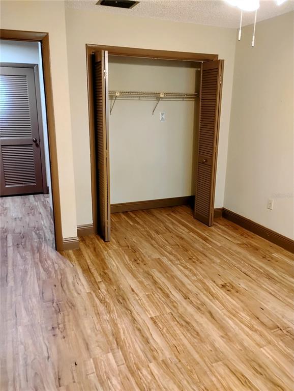 11721 Raintree Drive Tampa, FL 33617 - Photo 6 of 12 an empty room with wooden floor and closet