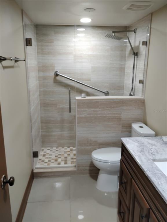 11721 Raintree Drive Tampa, FL 33617 - Photo 8 of 12 a bathroom with a granite countertop sink a toilet and shower