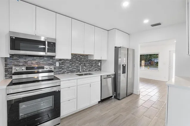 a kitchen with stainless steel appliances granite countertop a stove microwave and refrigerator