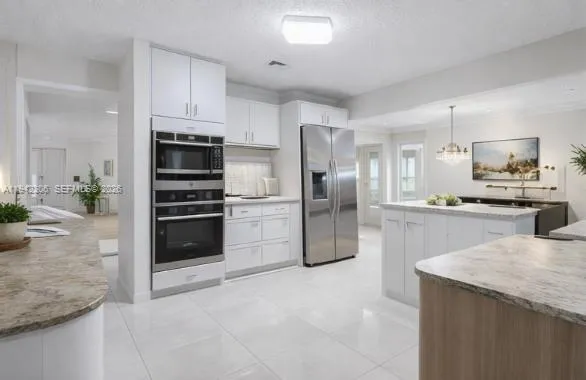 a kitchen with granite countertop a refrigerator and a sink