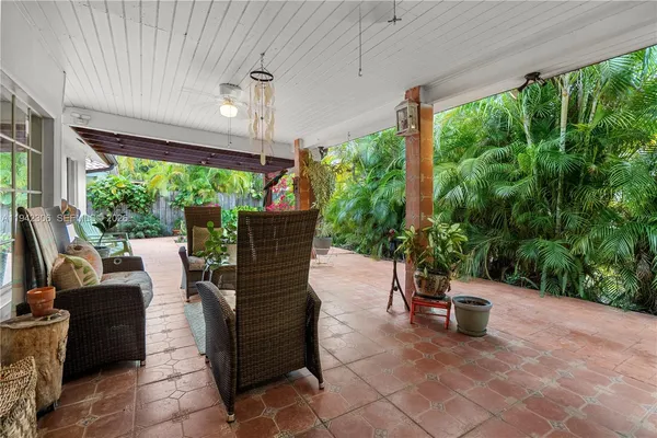 a living room with patio furniture and garden view