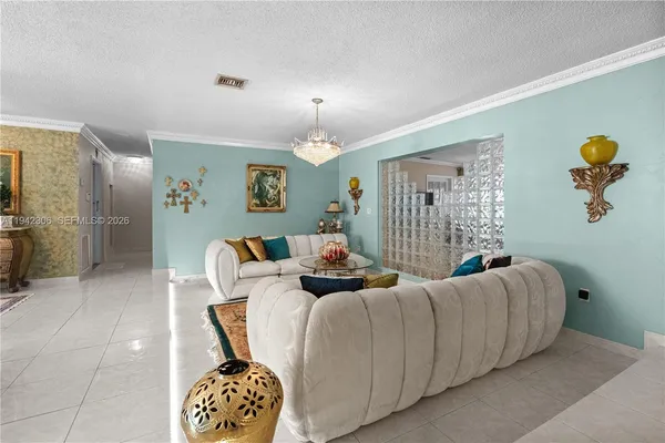 a living room with furniture a chandelier and a window