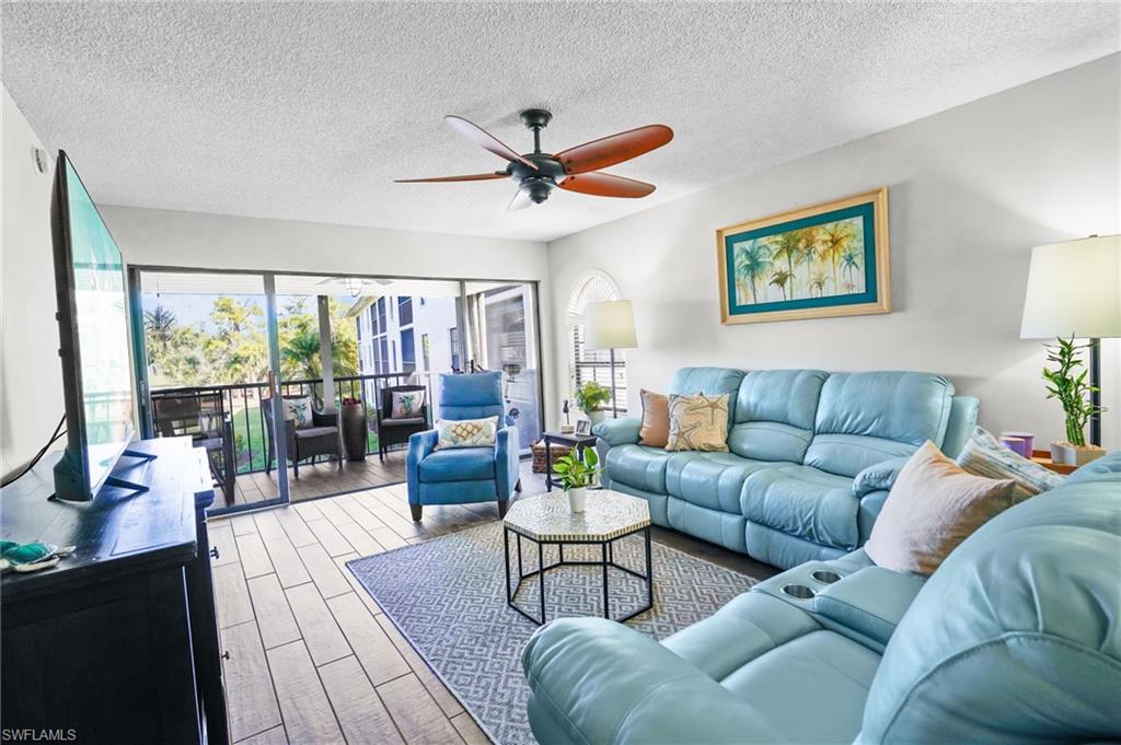 601 Augusta Boulevard, Unit 10 Naples, FL 34113 - Photo 2 of 27 Living area featuring wood finished floors, a ceiling fan, and a textured ceiling