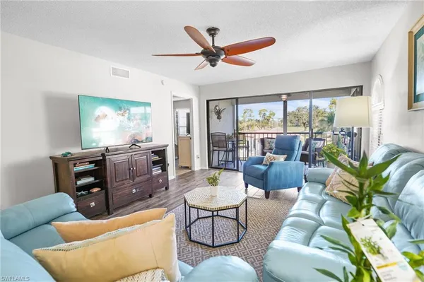 a living room with furniture a large window with wooden floor