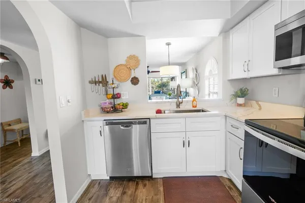 a kitchen with white cabinets and sink