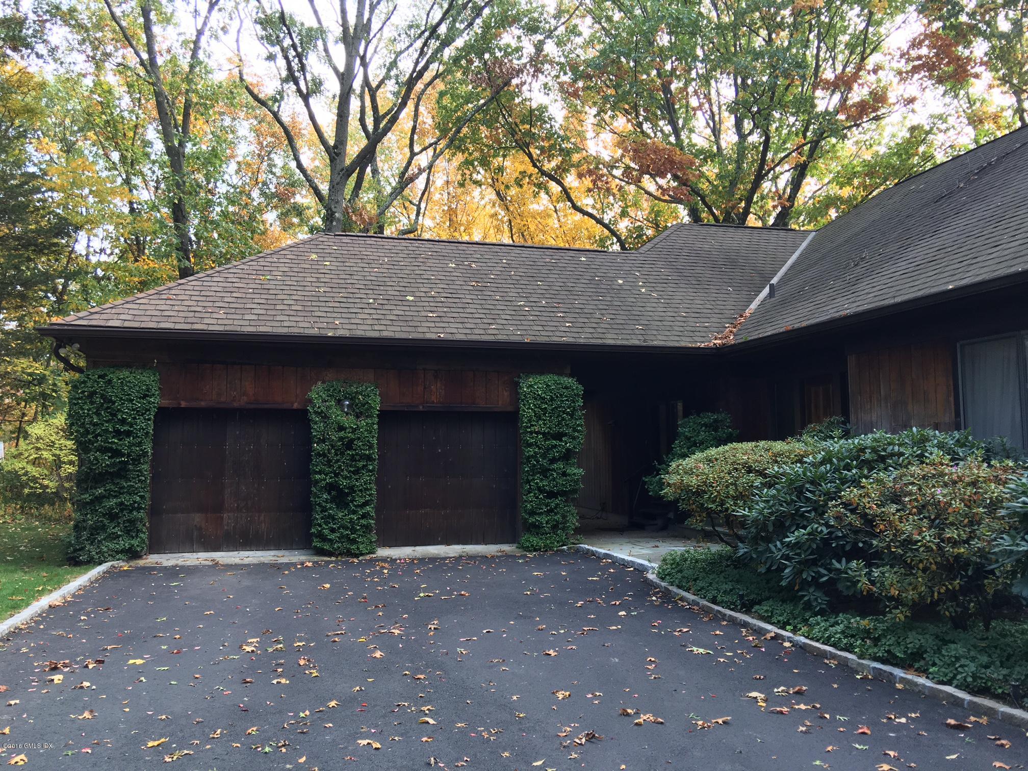 25 Bailiwick Road Greenwich, CT 06831 - Photo 3 of 7 a front view of a house with a garden and trees